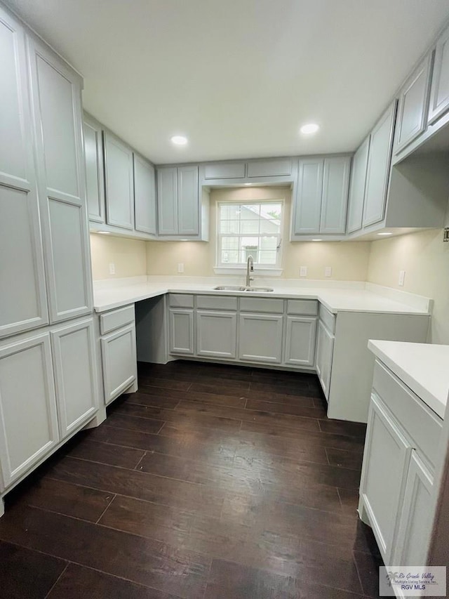 kitchen with dark hardwood / wood-style flooring, sink, and white cabinets