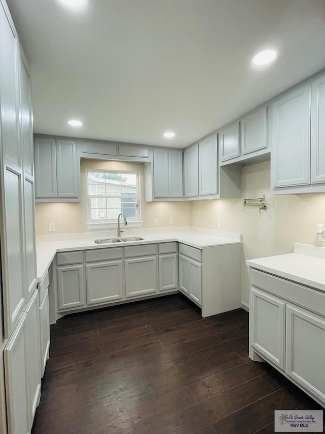 kitchen with white cabinets, dark wood-type flooring, and sink