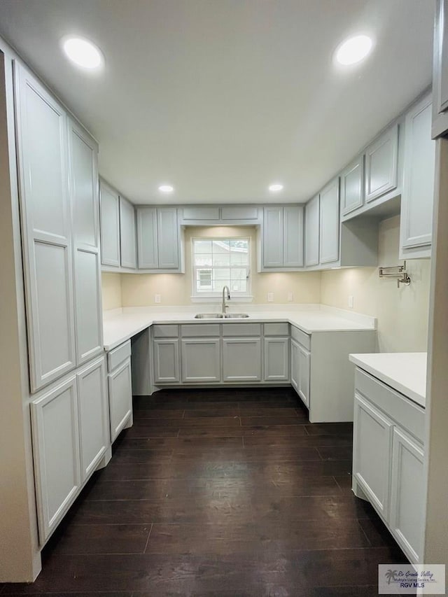 kitchen with dark hardwood / wood-style floors, white cabinetry, and sink