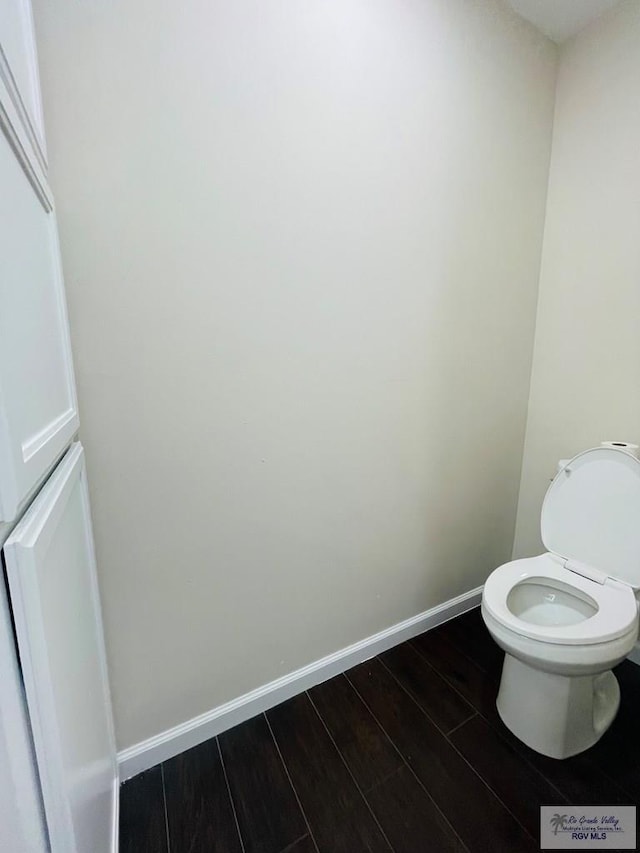 bathroom featuring wood-type flooring and toilet