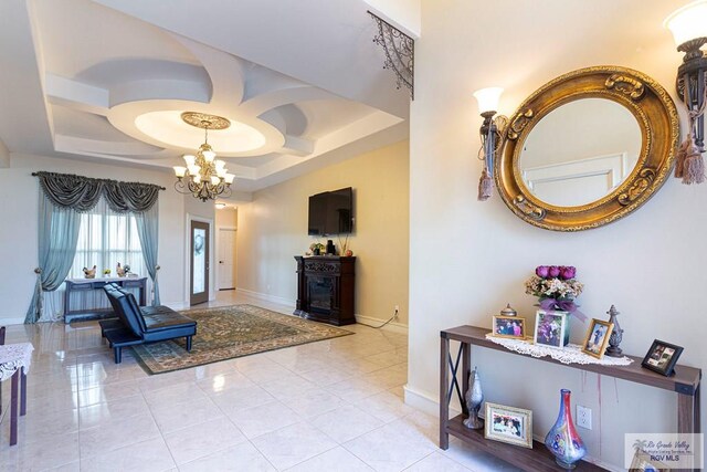 interior space featuring light tile patterned floors, a tray ceiling, and an inviting chandelier