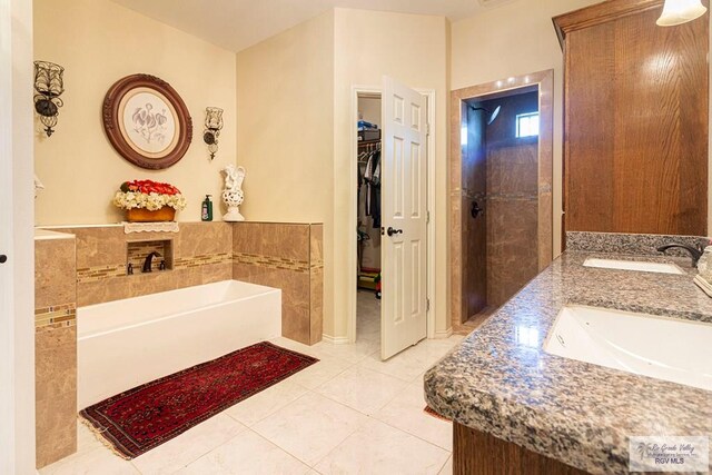 bathroom with tile patterned flooring, vanity, and a tub