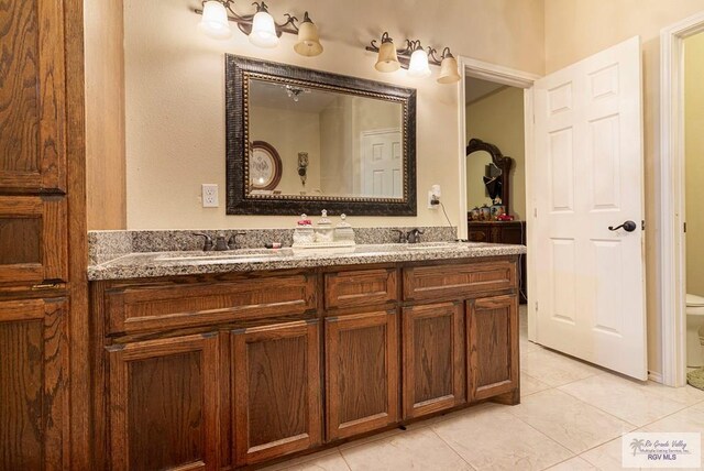 bathroom with tile patterned flooring, vanity, and toilet