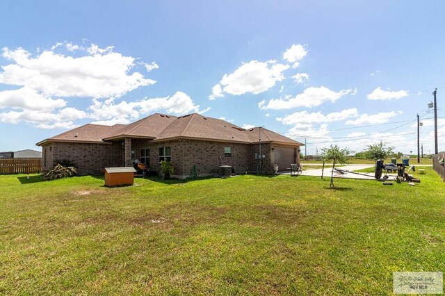 back of house featuring a lawn and central AC