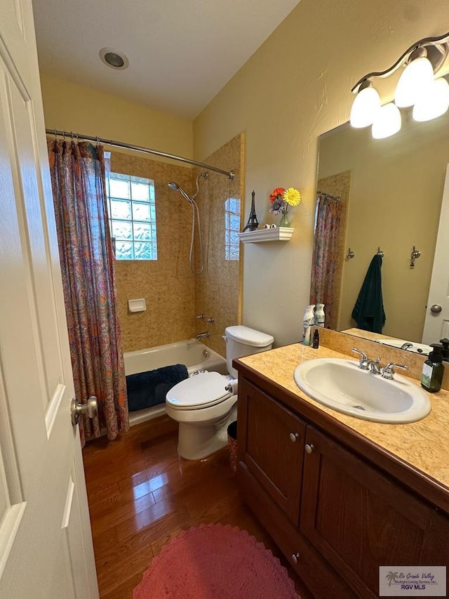 bathroom featuring toilet, shower / tub combo with curtain, wood finished floors, and vanity