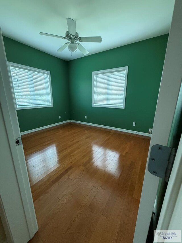 117 Palm Valley Cir, Harlingen, TX 78552 - spare room with wood finished floors, a ceiling fan, and baseboards