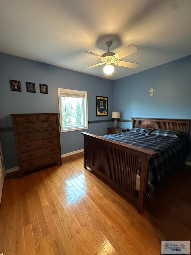 bedroom featuring light wood-style floors, baseboards, and a ceiling fan