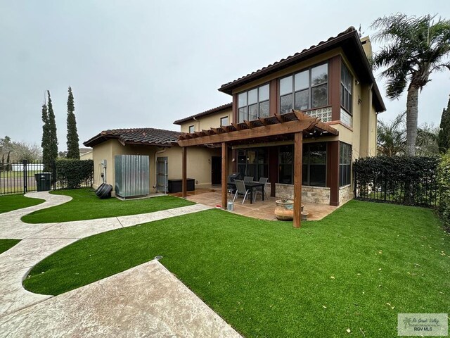 back of house featuring fence private yard, a patio area, stucco siding, and a yard