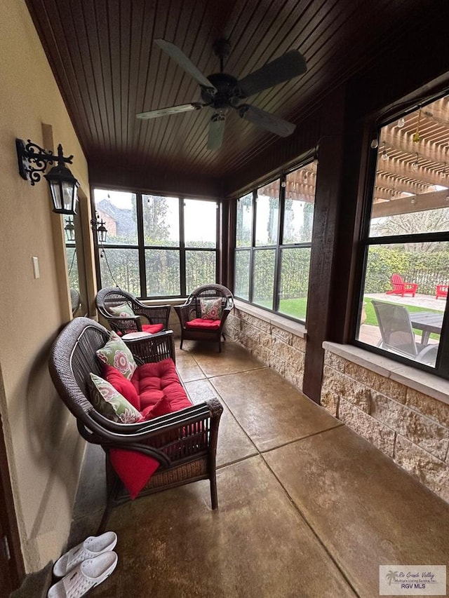 sunroom featuring ceiling fan and wood ceiling