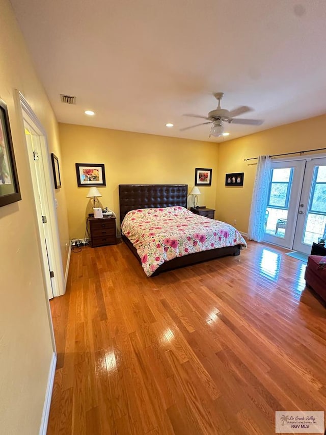 bedroom with access to outside, wood finished floors, and baseboards