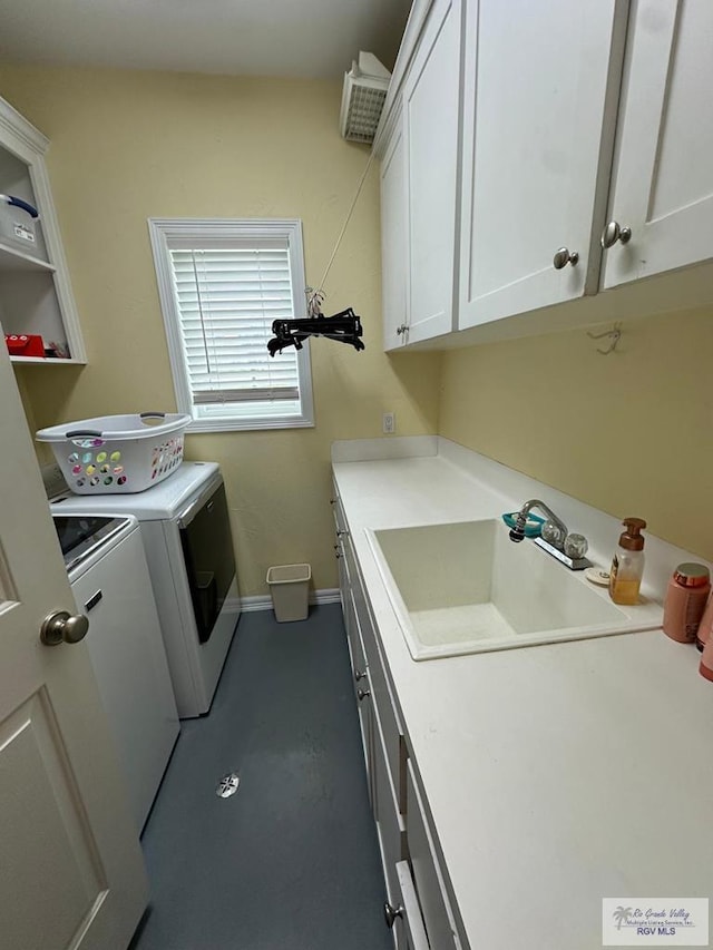 laundry area with cabinet space, baseboards, a sink, and washing machine and clothes dryer