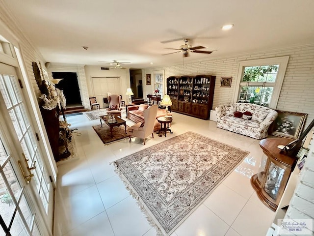 tiled living room with brick wall and ceiling fan