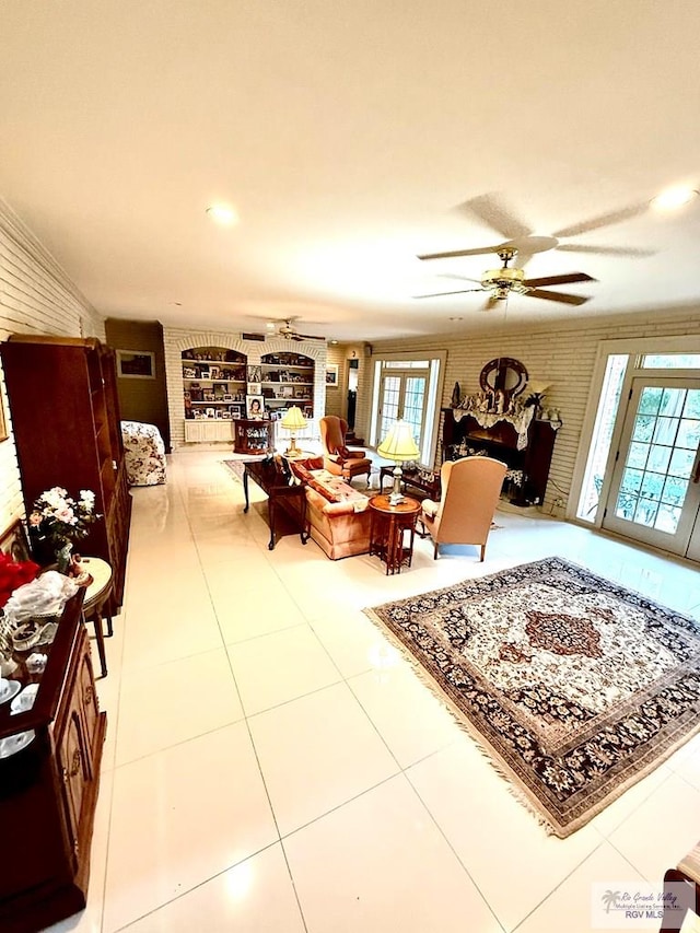 living room featuring tile patterned flooring, brick wall, and ceiling fan