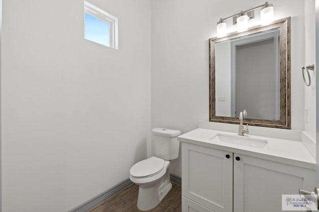 bathroom featuring vanity, wood-type flooring, and toilet