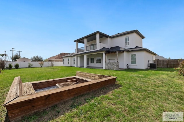 back of property featuring central AC, a balcony, and a yard