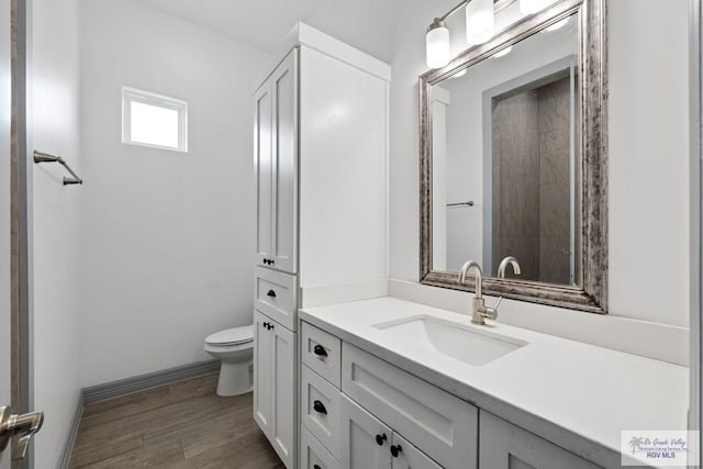 bathroom featuring vanity, hardwood / wood-style floors, and toilet