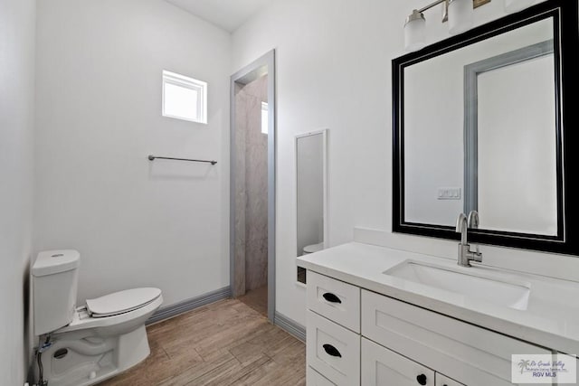 bathroom featuring hardwood / wood-style flooring, vanity, walk in shower, and toilet