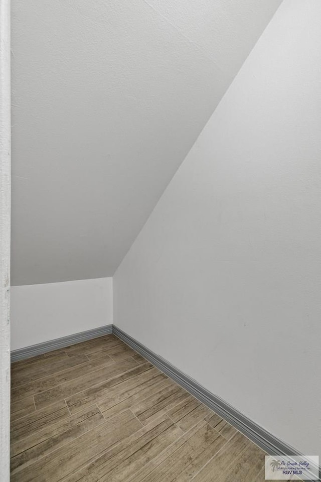 bonus room with hardwood / wood-style flooring and lofted ceiling