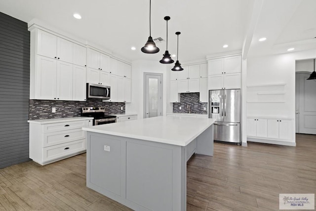 kitchen featuring white cabinetry, stainless steel appliances, and a kitchen island