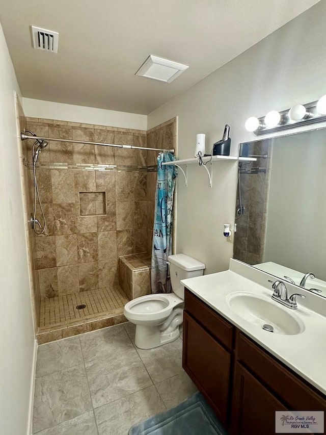 bathroom with tile patterned flooring, vanity, toilet, and walk in shower