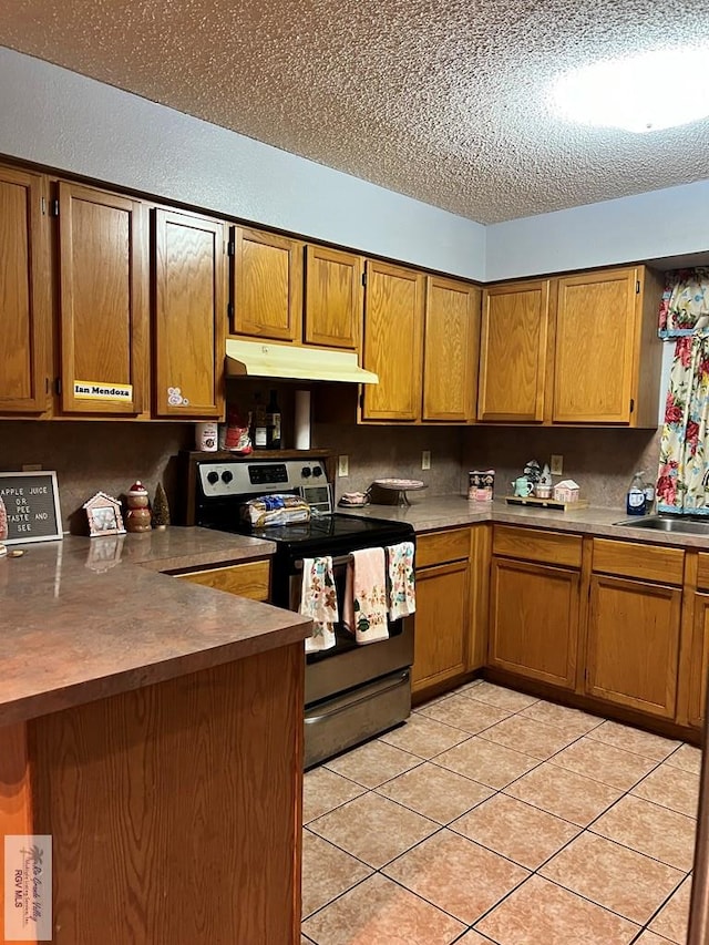 kitchen featuring electric range, light tile patterned flooring, sink, and a textured ceiling