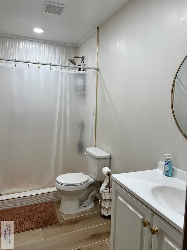 bathroom with hardwood / wood-style floors, vanity, toilet, and a shower with curtain