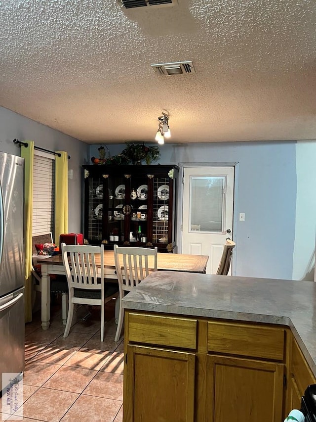 dining space featuring light tile patterned floors and a textured ceiling