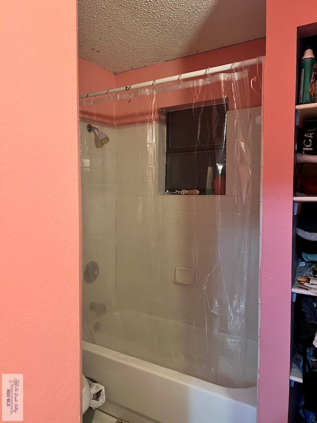 bathroom featuring shower / tub combo with curtain and a textured ceiling