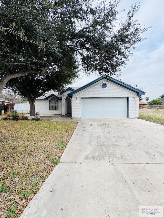 2200 E 19th St, Mission, TX 78572 - single story home with driveway, brick siding, an attached garage, and a front lawn