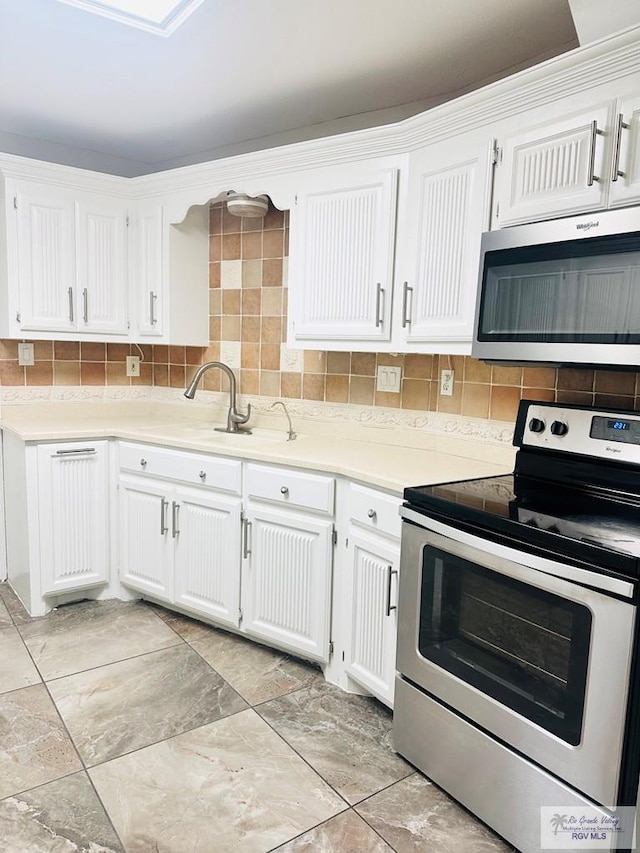 2200 E 19th St, Mission, TX 78572 - kitchen with appliances with stainless steel finishes, white cabinets, and decorative backsplash