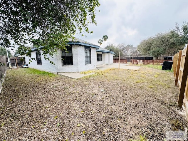 2200 E 19th St, Mission, TX 78572 - rear view of house featuring a patio, brick siding, and a fenced backyard