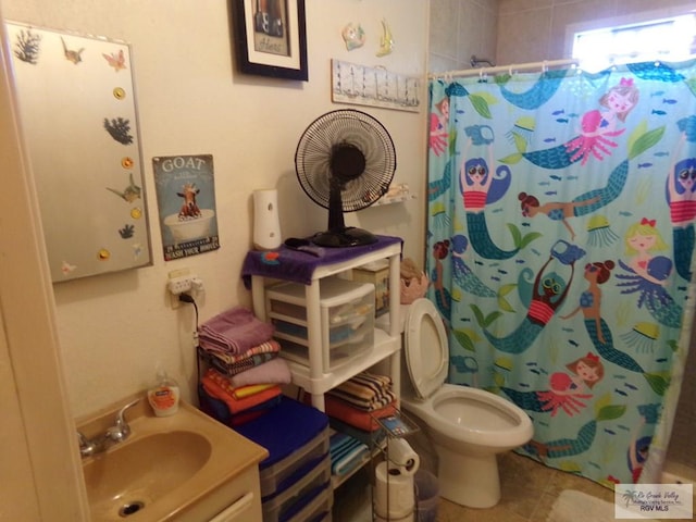 bathroom featuring tile patterned flooring, vanity, toilet, and walk in shower