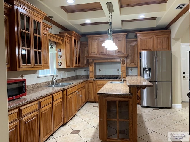 kitchen with light stone countertops, appliances with stainless steel finishes, ornamental molding, sink, and a kitchen island