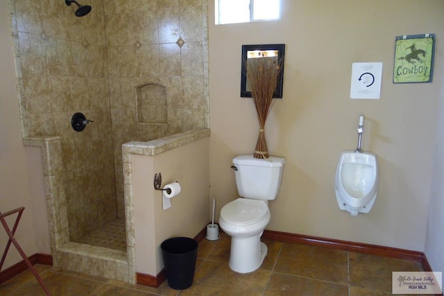 bathroom with a tile shower, tile patterned floors, and toilet