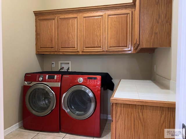 laundry room featuring separate washer and dryer, light tile patterned flooring, and cabinets