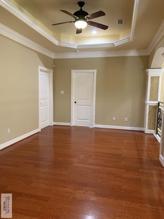 spare room featuring a tray ceiling, crown molding, ceiling fan, and dark hardwood / wood-style floors