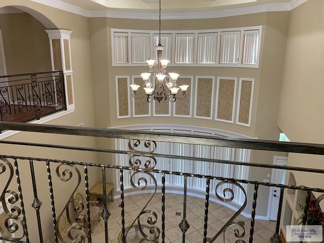 stairs with tile patterned flooring, a notable chandelier, and ornamental molding