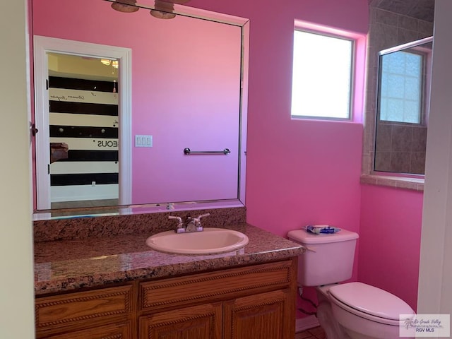 bathroom featuring vanity, toilet, and an enclosed shower