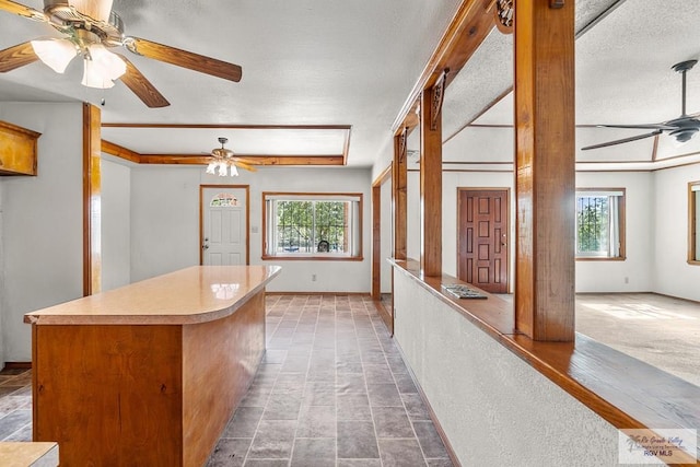 kitchen with a center island, a healthy amount of sunlight, carpet floors, and a textured ceiling