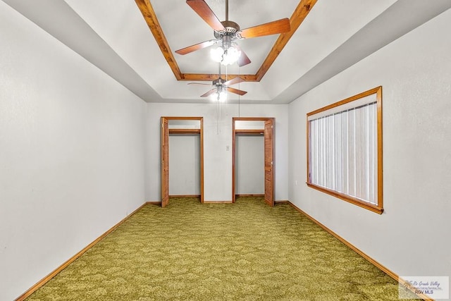 unfurnished bedroom with carpet, a raised ceiling, and ceiling fan