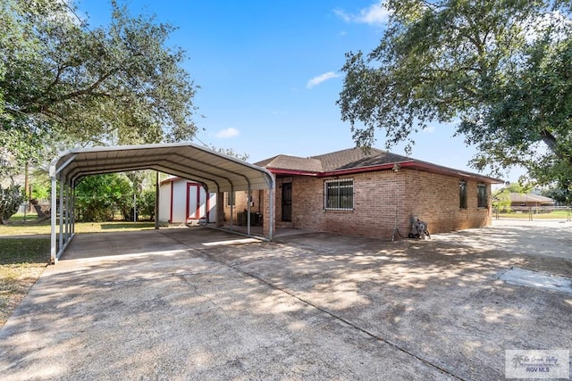 ranch-style house featuring a storage unit and a carport