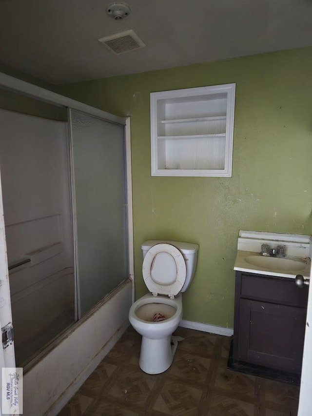 full bath featuring baseboards, visible vents, toilet, shower / bath combination with glass door, and vanity