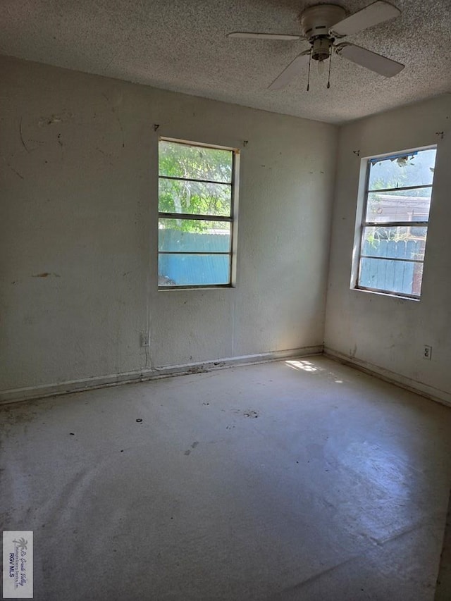 empty room with ceiling fan and a textured ceiling