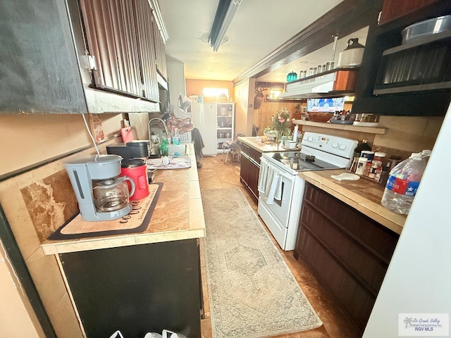 413 Cooper Ln Unit 24, 25, 26, La Feria, TX 78559 - kitchen with electric range, under cabinet range hood, light countertops, open shelves, and dark brown cabinetry