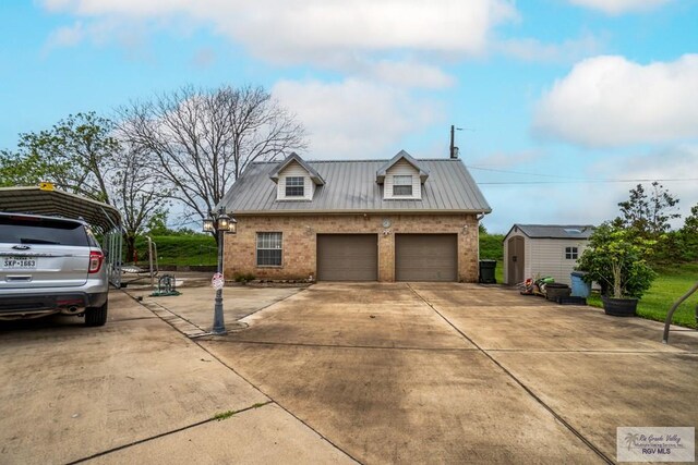 413 Cooper Ln Unit 24, 25, 26, La Feria, TX 78559 - view of front of property featuring a storage shed, brick siding, a garage, an outbuilding, and metal roof