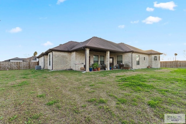 rear view of property with a yard and central AC unit