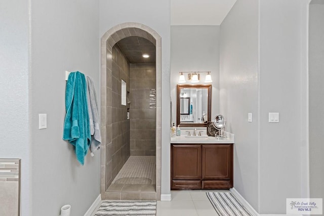 bathroom with tile patterned floors, vanity, and a tile shower