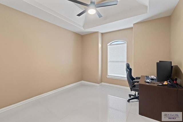 tiled office featuring ceiling fan and a raised ceiling