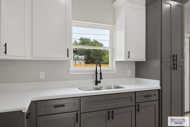 kitchen with gray cabinets, white cabinetry, and sink