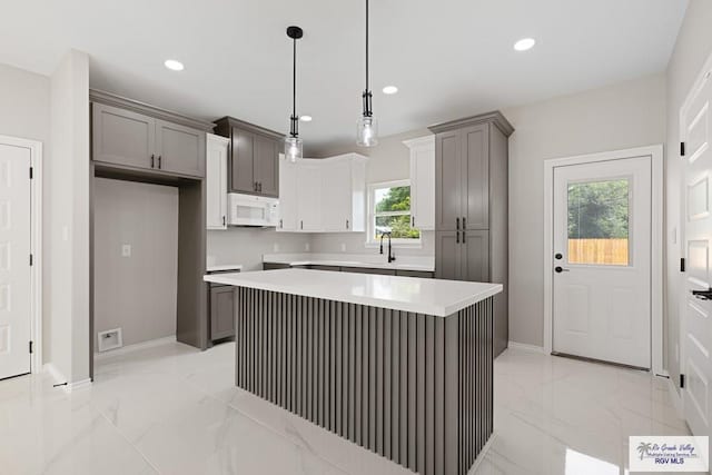 kitchen with decorative light fixtures, a kitchen island, and plenty of natural light